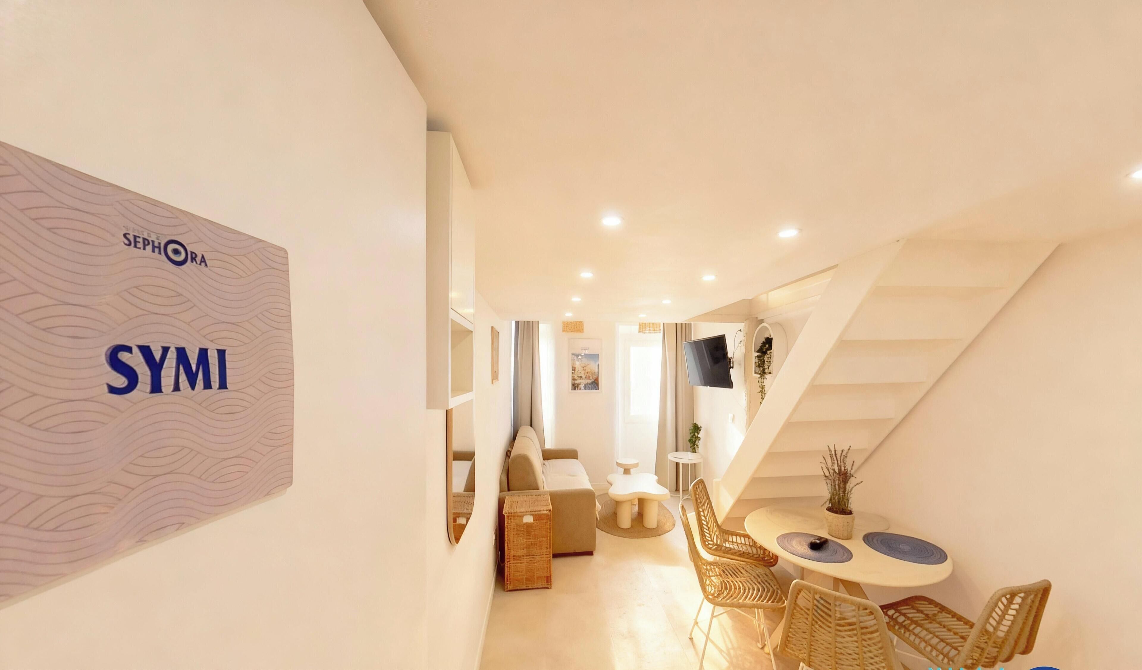 A modern interior with a sofa, a dining table with chairs, and a staircase.