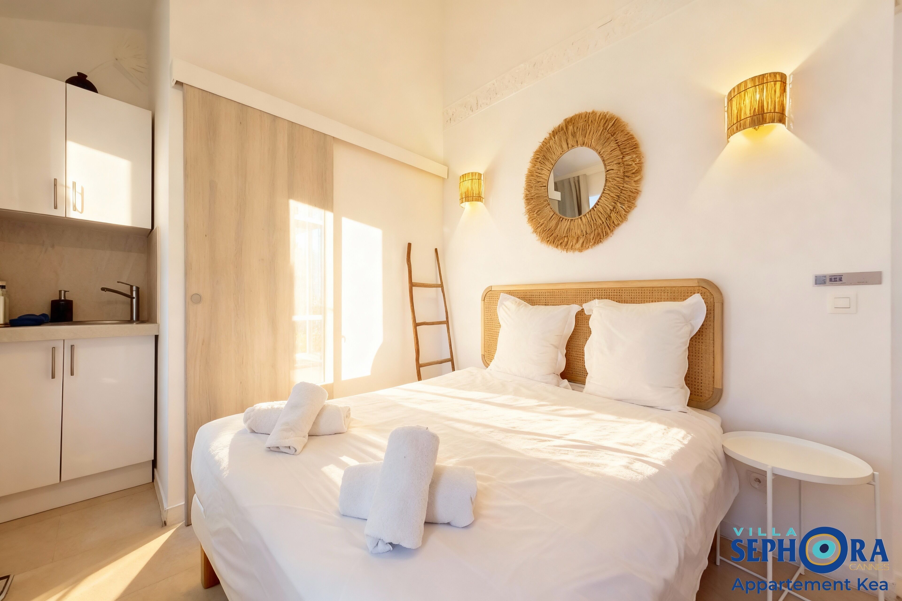 A hotel room with a bed, a bedside table, a wardrobe, and a bathroom.