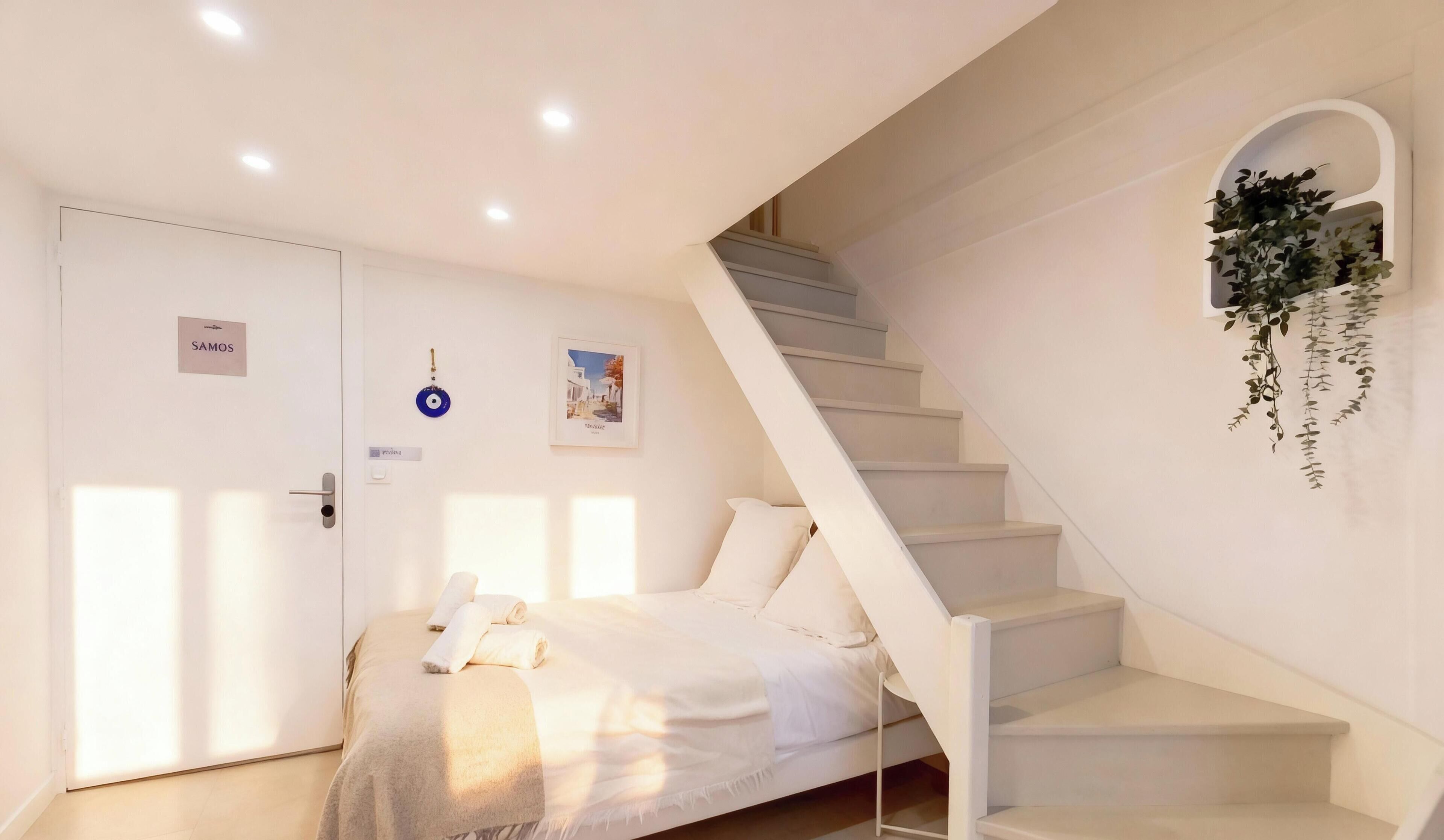 Un dormitorio con cama, escalera, una puerta con un letrero y una planta en la pared.