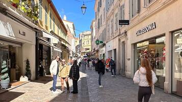 A pedestrian street lined with shops and cafes, featuring a mix of architectural styles and outdoor seating areas.