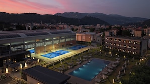 Ein Hotel mit Tennisplatz, Schwimmbad und angelegtem Garten.