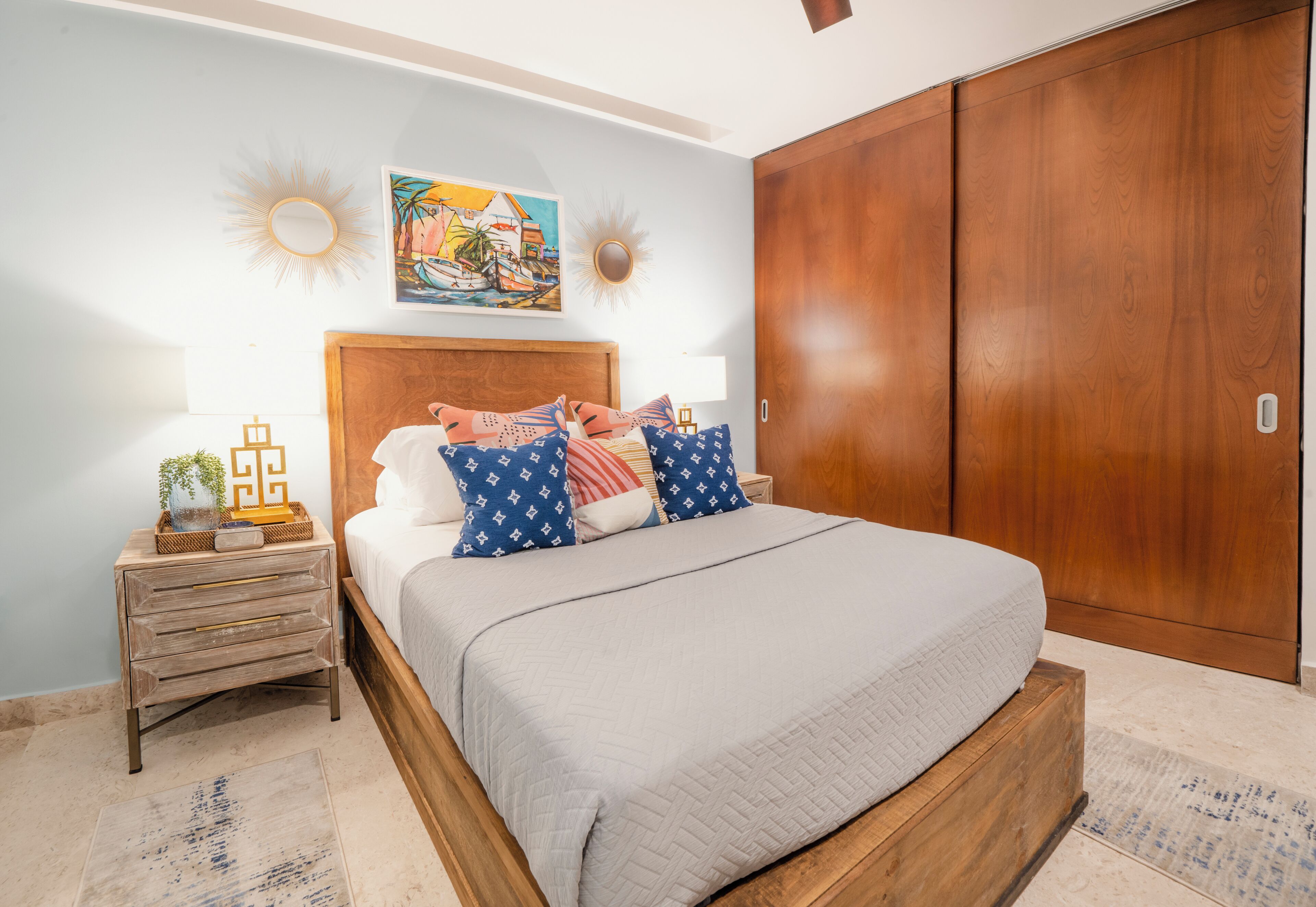 Een slaapkamer met een groot bed, een houten hoofdbord en een kledingkast.