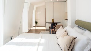 Une chambre moderne avec un grand lit, une petite table ronde et une chaise.