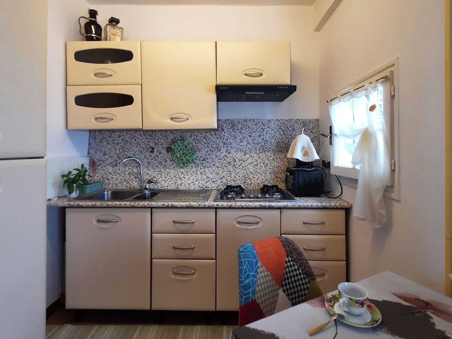 A compact kitchen with a gas stove, sink, and cabinets.