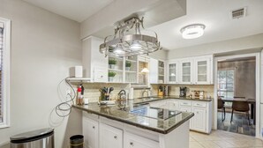 A modern kitchen with white cabinetry, a granite countertop, and a central island. - Modern Home with Private Pool, Minutes to NRG & Med Center (Houston)
