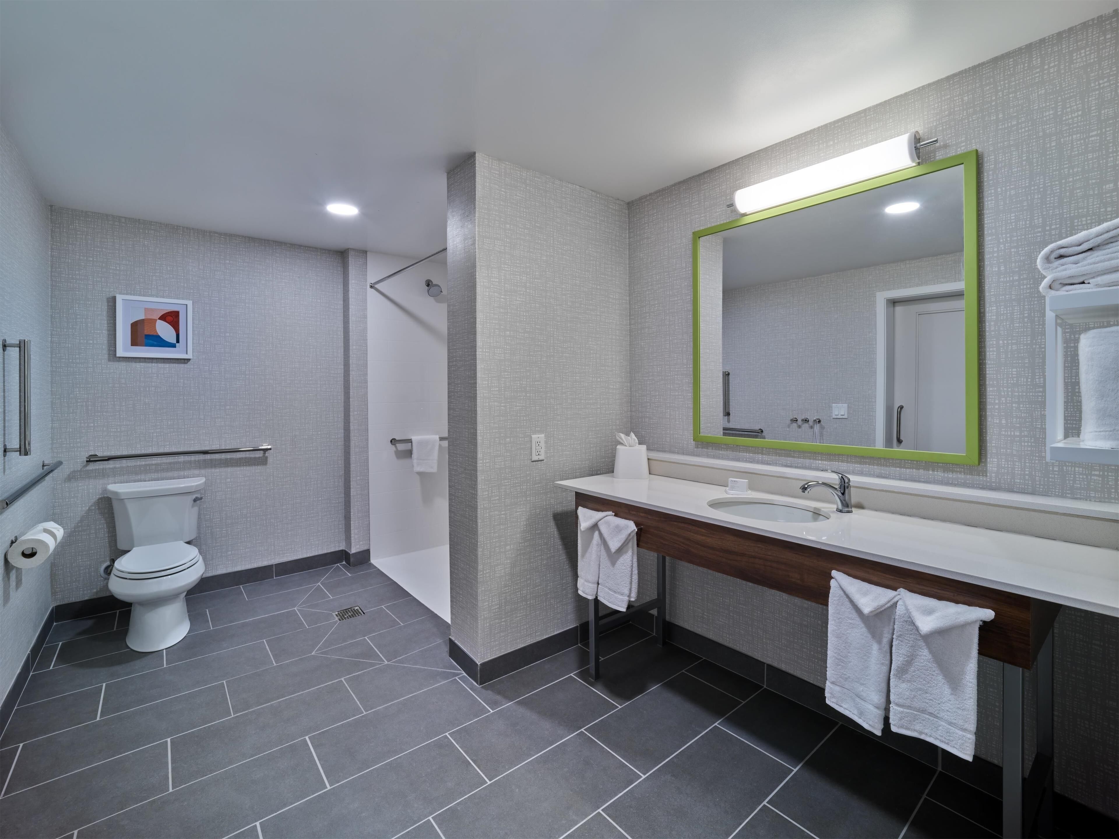 A modern bathroom with a toilet, sink, and shower.