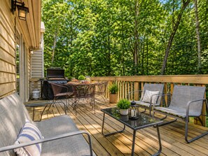 A wooden deck with outdoor furniture, a grill, and a view of a forest. - Modern spacious 4 bedroom retreat with 3 en-suites and all year round hot tub (Galena)