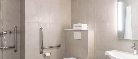 A modern bathroom with a shower, toilet, and sink.