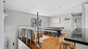 A modern kitchen with a dining table, a bench, and a staircase with a railing. - Stylish Quiet Adobe - Elbert (Thornton)