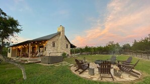 A stone building with a porch, outdoor seating, and a fire pit. - The Outpost Vacation Cabin Fredericksburg TX Pet Friendly Hot Tub Near Enchanted Rock (Fredericksburg)