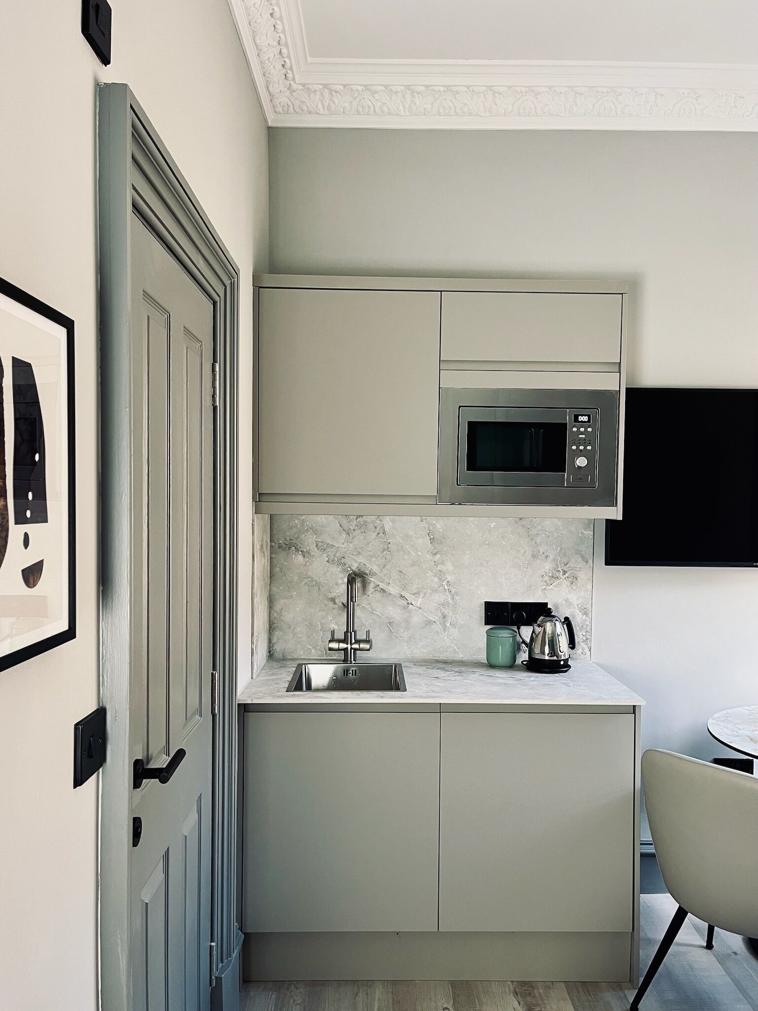 A compact kitchen with a built-in microwave, a sink, and a small countertop.
