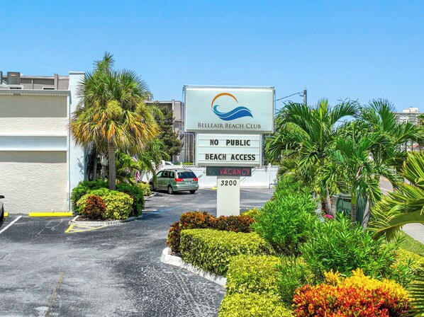 A sign for Belleair Beach Club with a no public beach access notice and a vacancy sign.