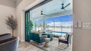 Un salón moderno con vistas a una piscina y al agua.