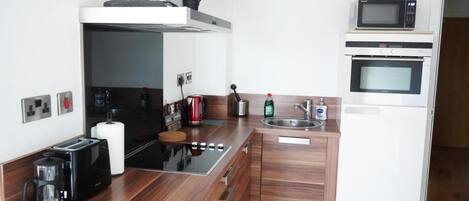 A modern kitchen with a built-in stove, microwave, and sink.