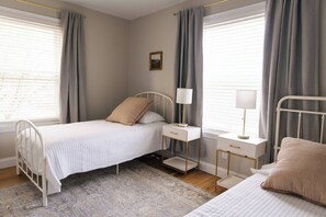 A bedroom with a single bed, bedside tables, and a nightstand. - The 1850 Retreat Chambersburg (Chambersburg)