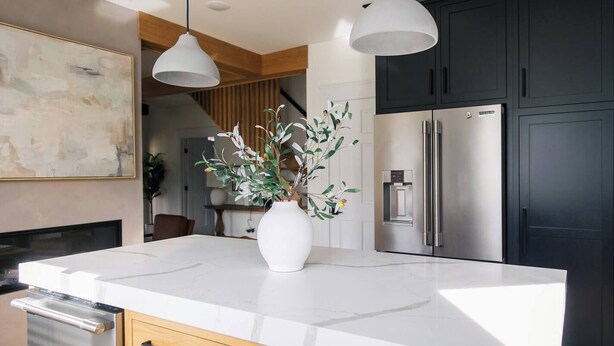 A modern kitchen with a large island, stainless steel appliances, and a minimalist design.