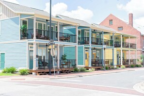 Une rangée de maisons de ville avec des balcons, une cheminée en briques et une vue sur la rue.