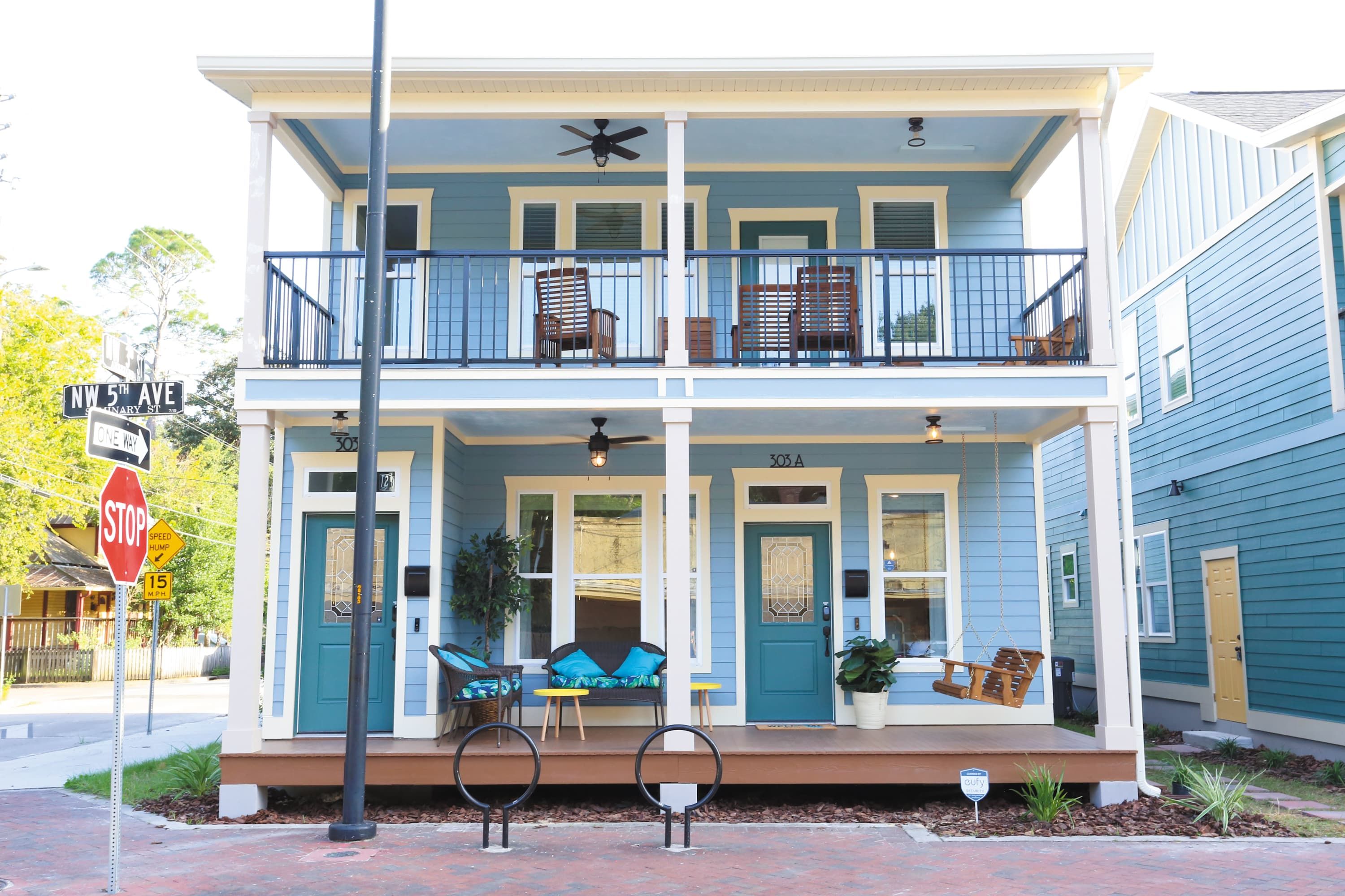 A two-story house with a porch, a balcony, and a front door.