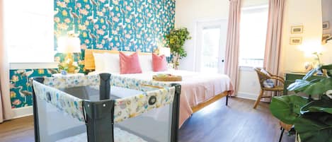 Un dormitorio con una cama, una silla, una mesa y una planta grande.