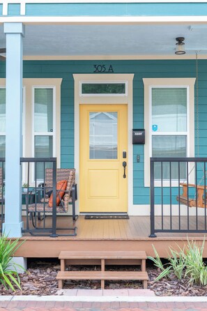 A yellow door with the number 305A, a porch with a bench, and a small table. - The Prairie Suite. Newly Built, Upscale, Central (Gainesville)