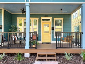 A building with a yellow door, a porch with a bench, and a mailbox. - The Prairie Suite. Newly Built, Upscale, Central (Gainesville)