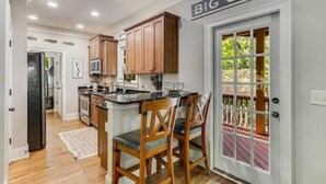 A kitchen with wooden cabinets, a black countertop, and two bar stools.