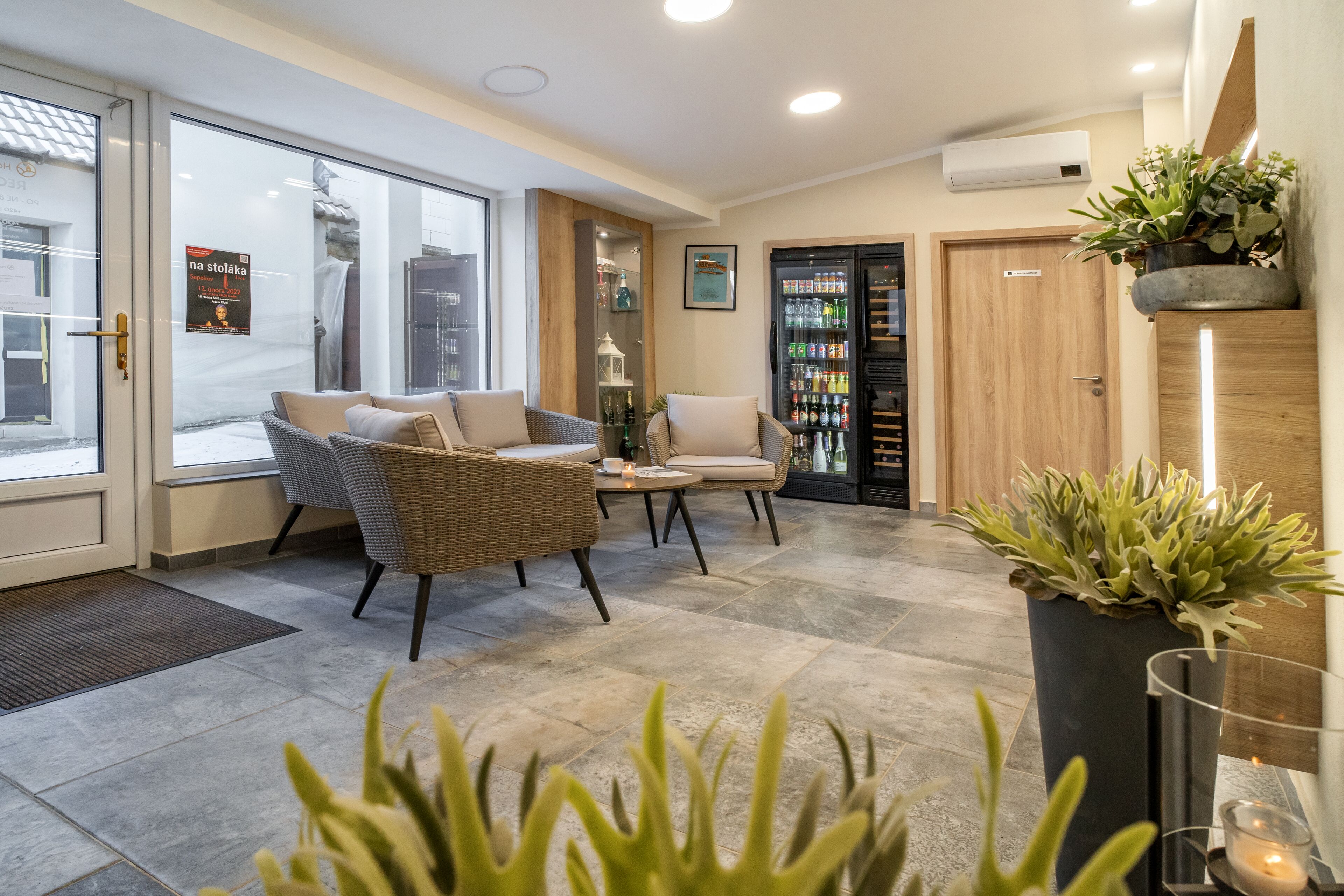 Un vestíbulo moderno con muebles de mimbre, una mesa de centro y una planta en maceta.