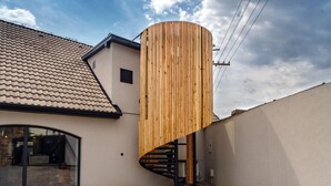 A modern house with a spiral staircase and a wooden cylindrical structure.