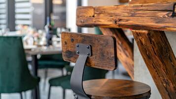 A wooden chair with a metal backrest and a round wooden seat.