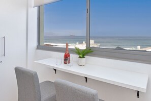 Enjoy ocean views from the large window, relax in the seating area with two chairs, or work at the console table.