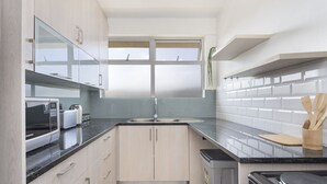Une cuisine moderne équipée d’un four à micro-ondes, d’un grille-pain, d’un évier et d’une cuisinière.