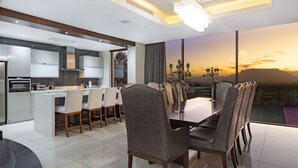 A modern kitchen with a dining area, large windows, and a chandelier. - Baronetcy Kings Villa (Cape Town)