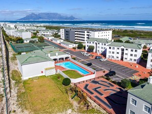 Zona residencial con piscina, estacionamiento y vistas al océano.