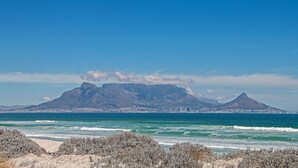 A coastal landscape with a mountain range and a city in the background. - Blouberg Heights 603 (Cape Town)