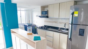 Una cocina moderna con un refrigerador de acero inoxidable, un microondas y una estufa a gas.