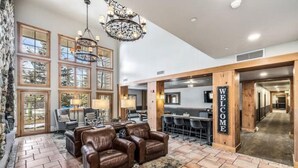 A spacious lobby with a fireplace, leather seating, and a bar area.