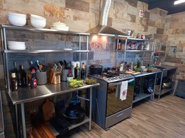 Una cocina moderna con electrodomésticos de acero inoxidable, piso de madera y un salpicadero de piedra.