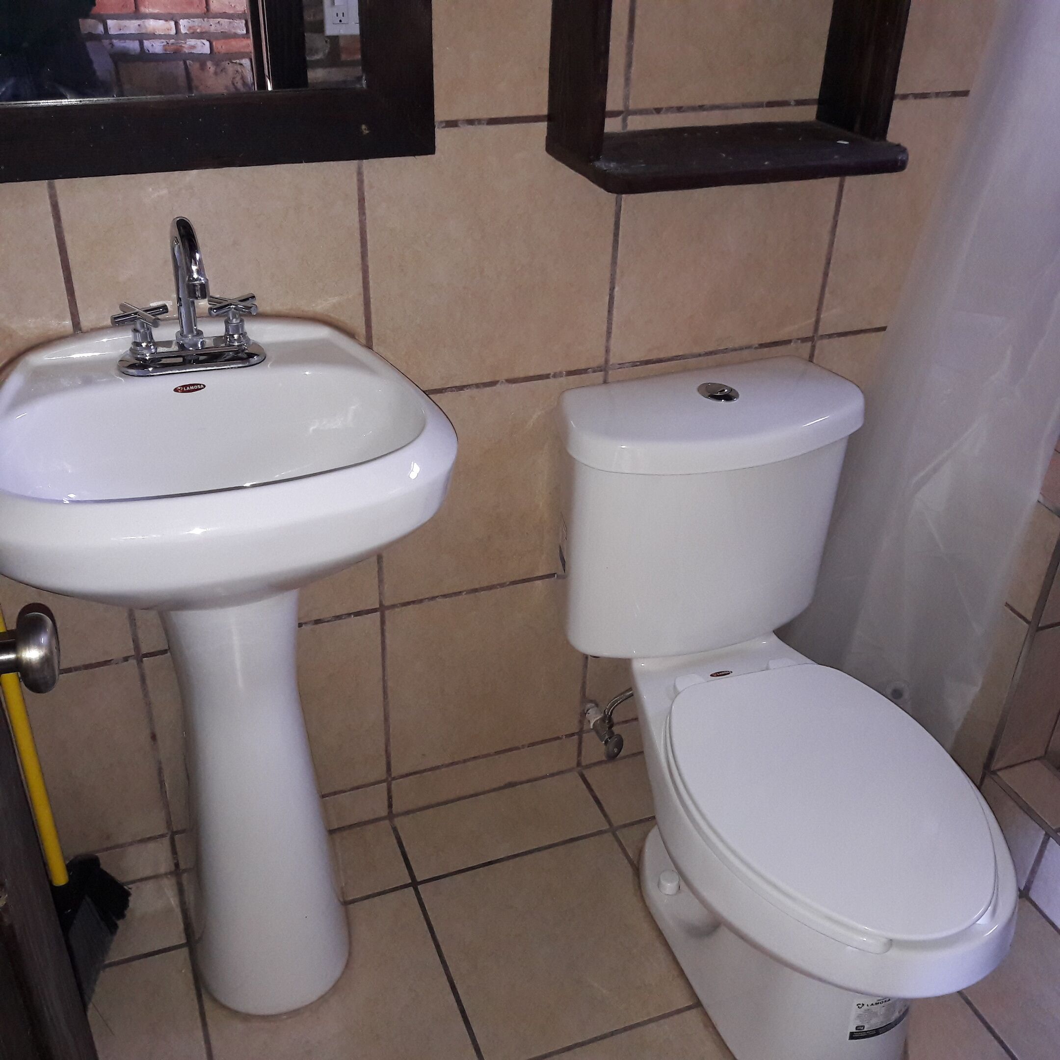 A bathroom with a white sink, a toilet, and a mirror above the sink.
