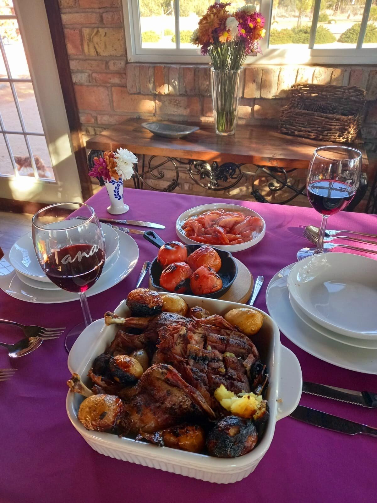 A dining table with a variety of dishes, including roasted meats and vegetables, set on a purple tablecloth.