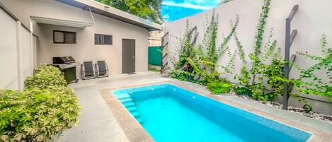 Una piscina al aire libre, tumbonas