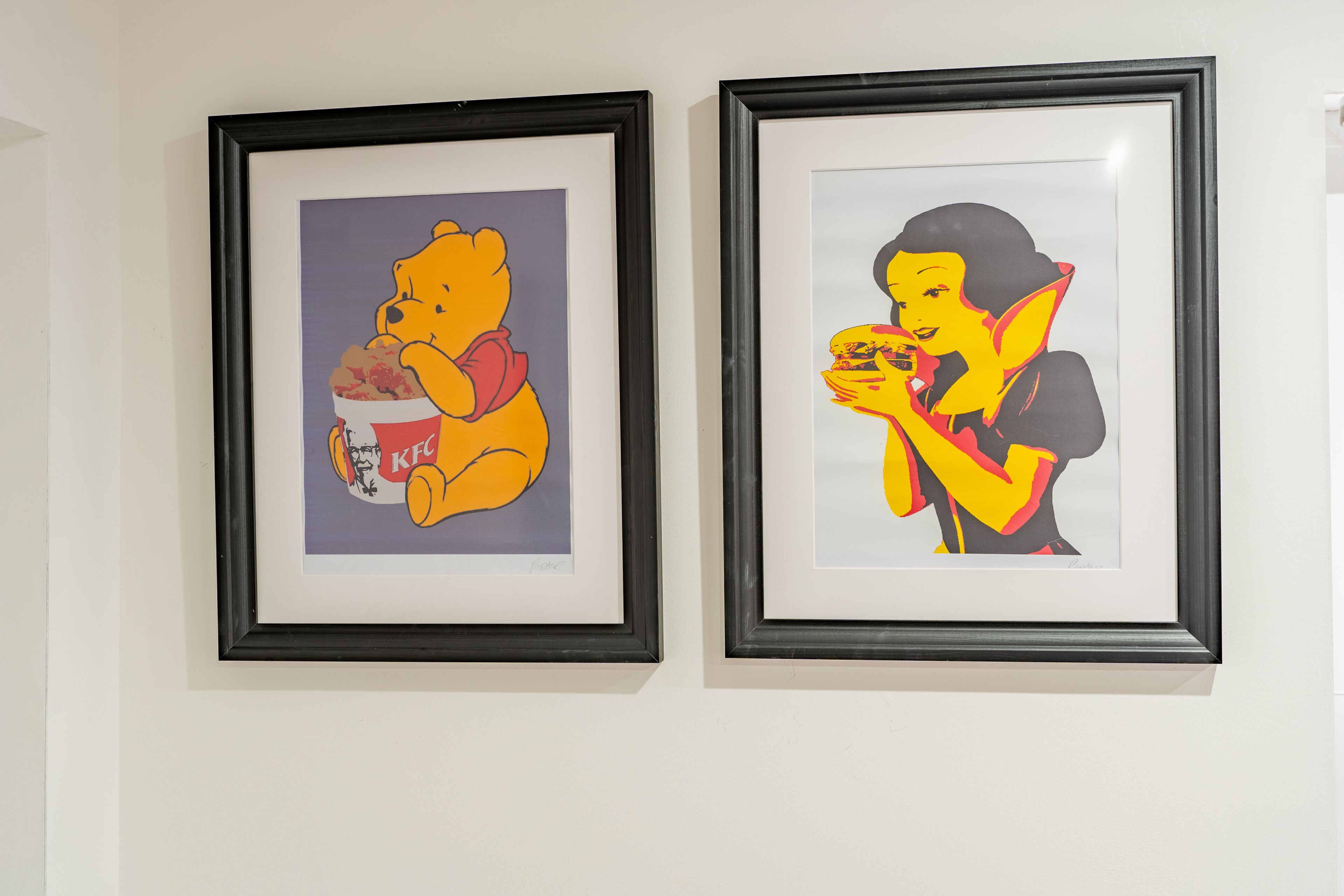 Deux œuvres d’art encadrées sont accrochées au mur.