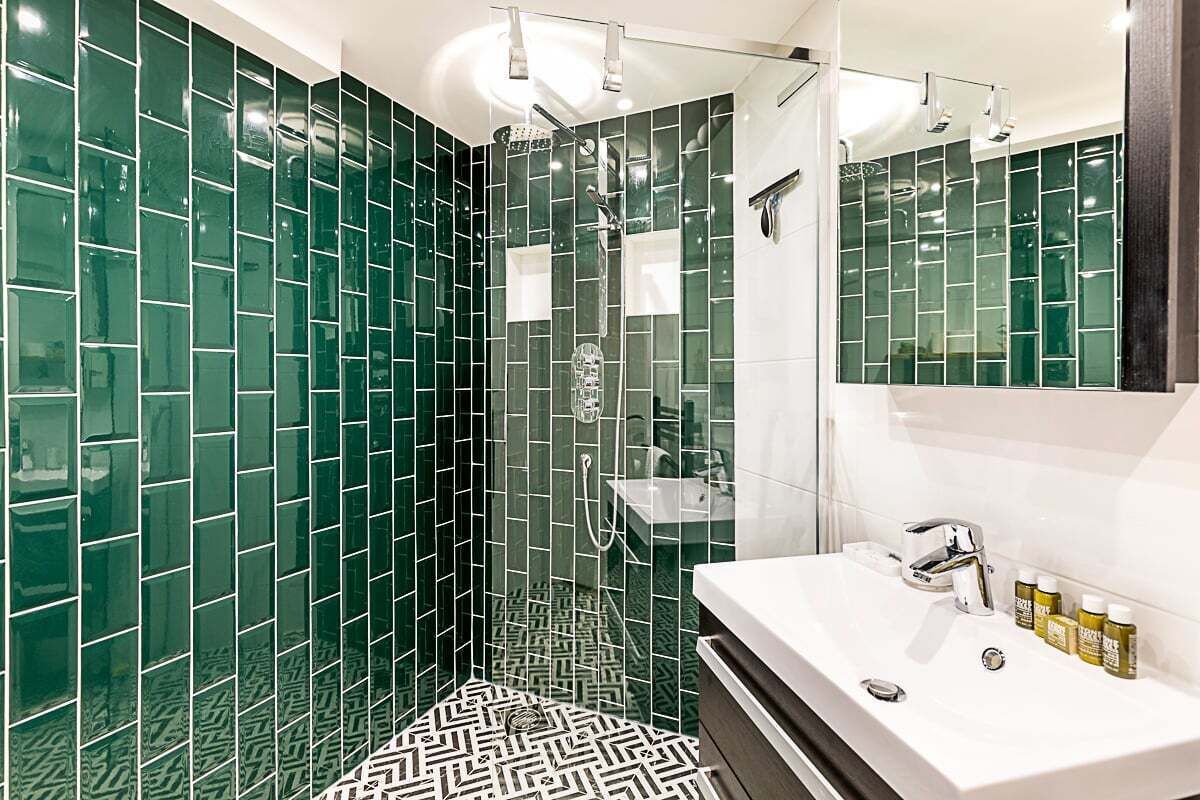 A modern bathroom with a shower, a sink, and a mirror.