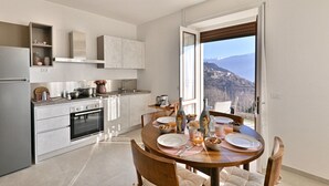 Cocina moderna con comedor, vistas a la montaña y un balcón.