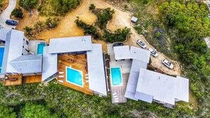 An aerial view of a residential area with multiple houses, each featuring a swimming pool.