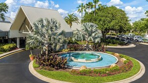A hotel with a swimming pool, palm trees, and a parking lot. - Peaceful 2BR Villa at Marriott Sabal Palms – Full Kitchen + Quiet Resort Setting (Orlando)