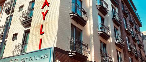 Un hotel con un cartel que dice "HOTEL DAYLI" y "IN USTA SÜT TATILAR!", indicando la existencia de un baño turco.