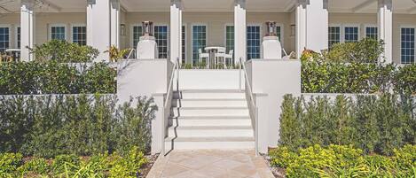 A building with a central staircase leading to a covered area with outdoor seating.