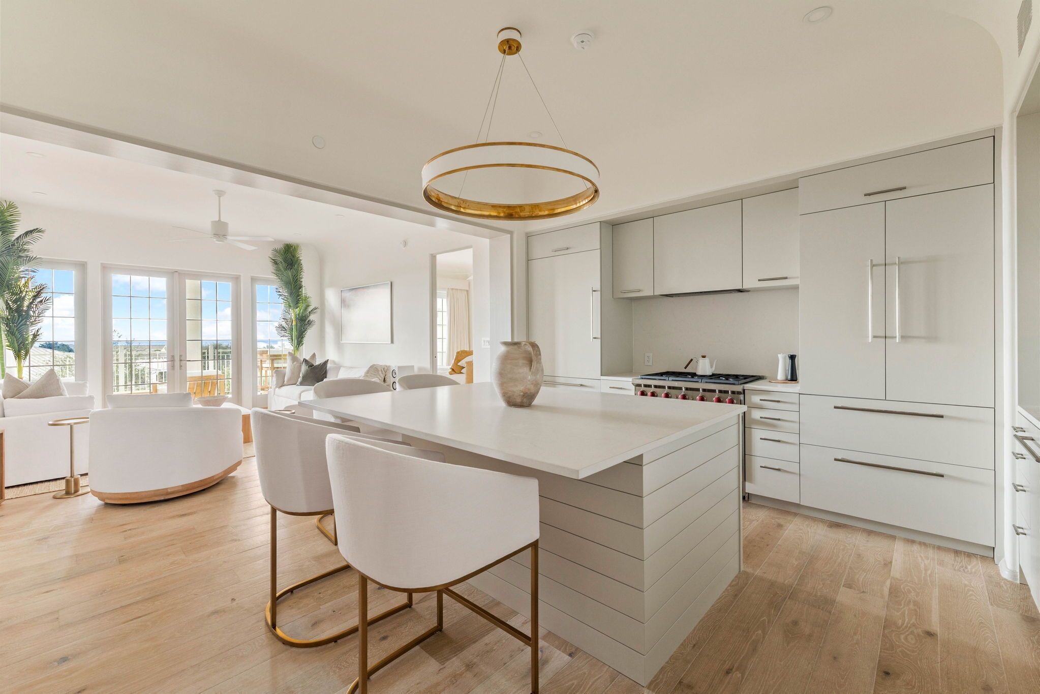 A modern kitchen with white cabinetry, a central island, and a pendant light.