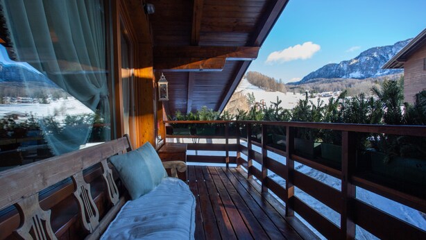 A wooden deck with a bench and a view of a snowy mountain landscape. - Elegant Ampezzo-style apartment with breathtaking views of the Dolomites. (Cortina d'Ampezzo)