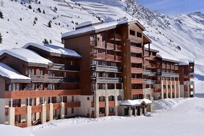 A multi-story hotel with balconies, set against a snowy mountainous backdrop. - Ski-in/ski-out & foot of the slopes, 5th floor, view ski slopes, balcony, tv, ski locker, 23m² (La Plagne)